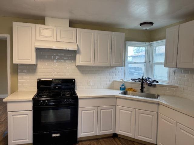 kitchen with backsplash, light countertops, black range with gas cooktop, white cabinets, and a sink