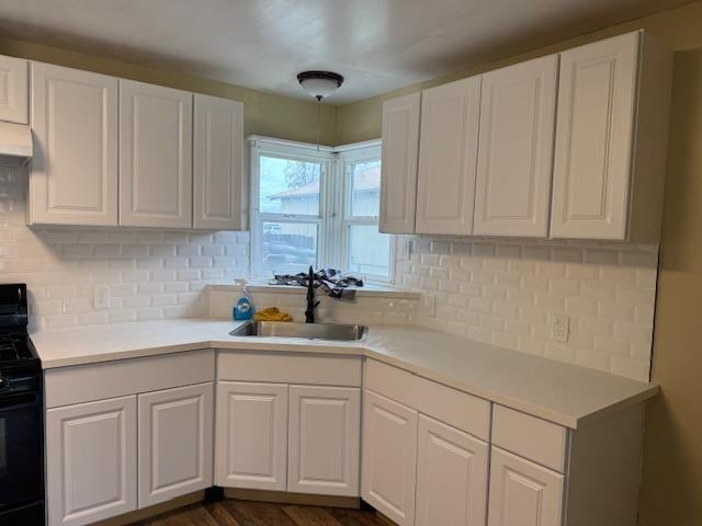 kitchen featuring a sink, black / electric stove, white cabinets, and light countertops