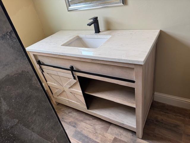 interior details with baseboards, wood finished floors, and vanity