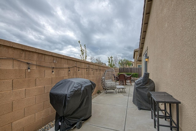 view of patio with outdoor dining area, area for grilling, and a fenced backyard