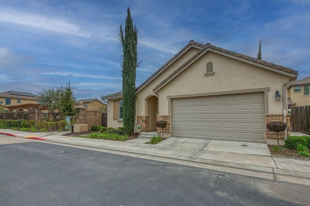 view of front of home with fence, driveway, stucco siding, a garage, and stone siding