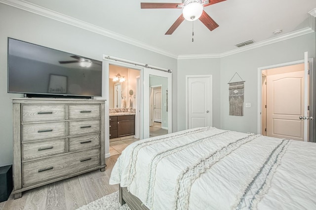 bedroom with a ceiling fan, visible vents, ensuite bath, light wood-style floors, and crown molding