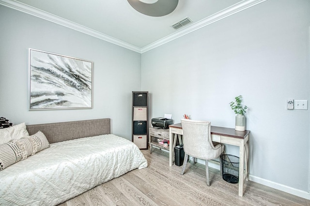 bedroom with visible vents, baseboards, wood finished floors, and ornamental molding