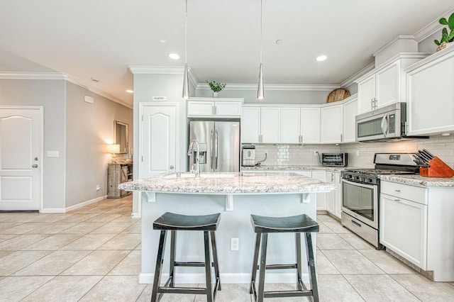 kitchen with a kitchen bar, backsplash, appliances with stainless steel finishes, light tile patterned flooring, and white cabinets