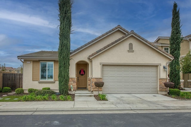 view of front of property featuring fence, stucco siding, concrete driveway, a garage, and stone siding