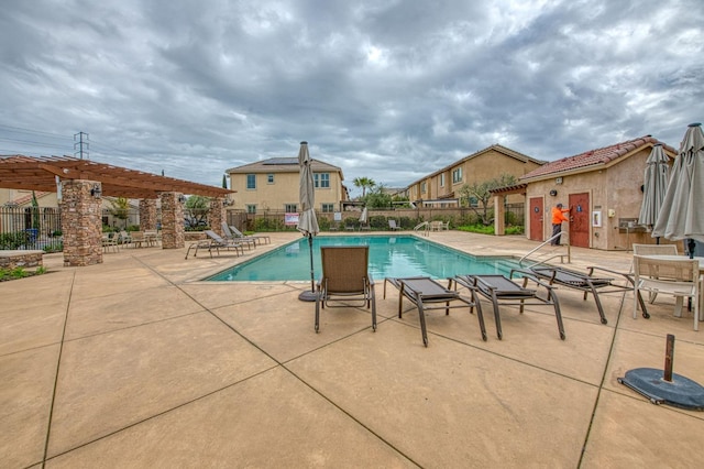 pool with a patio area, fence, and a pergola