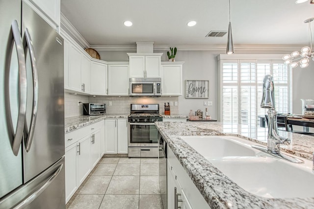 kitchen with visible vents, ornamental molding, decorative backsplash, a sink, and appliances with stainless steel finishes