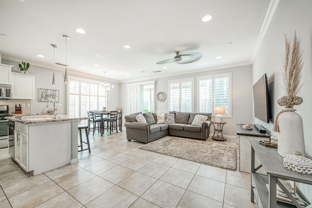 living area featuring light tile patterned floors, visible vents, recessed lighting, ornamental molding, and ceiling fan with notable chandelier