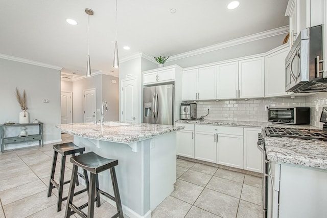 kitchen featuring tasteful backsplash, appliances with stainless steel finishes, light tile patterned flooring, white cabinetry, and a sink