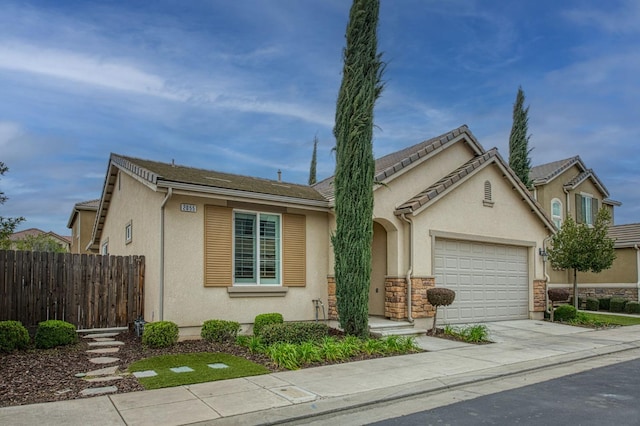 view of front of property featuring fence, an attached garage, stucco siding, concrete driveway, and stone siding