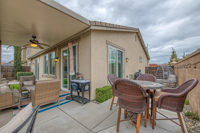 view of patio with outdoor dining space, a ceiling fan, outdoor lounge area, and a fenced backyard