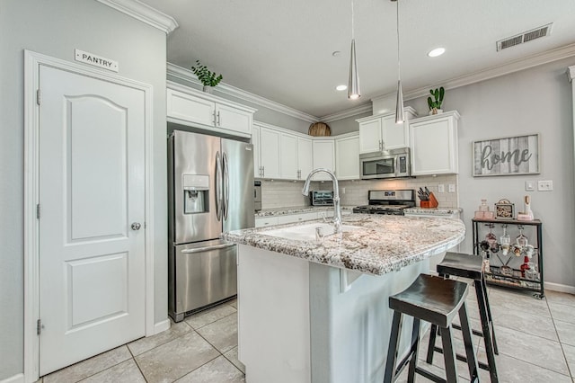 kitchen with visible vents, a sink, appliances with stainless steel finishes, crown molding, and tasteful backsplash