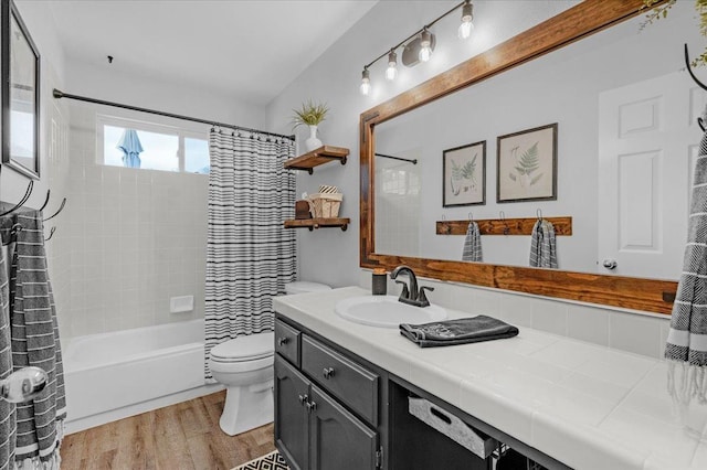 full bathroom with shower / tub combo with curtain, toilet, vanity, and wood finished floors