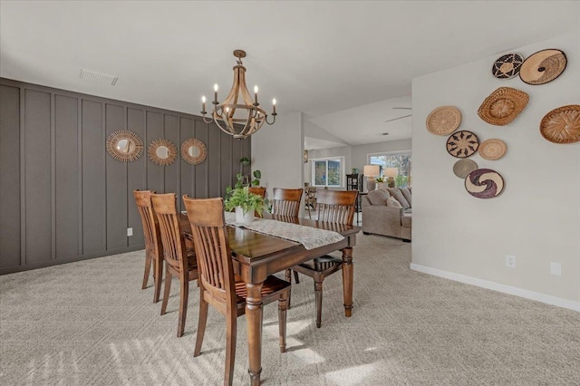 dining area with baseboards, visible vents, vaulted ceiling, light colored carpet, and a chandelier