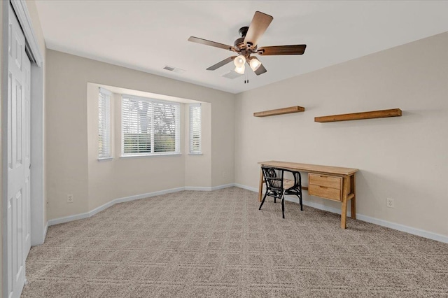 carpeted home office featuring visible vents, baseboards, and ceiling fan