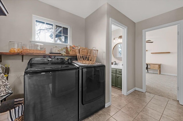 laundry room featuring washing machine and dryer, light tile patterned flooring, baseboards, light colored carpet, and laundry area