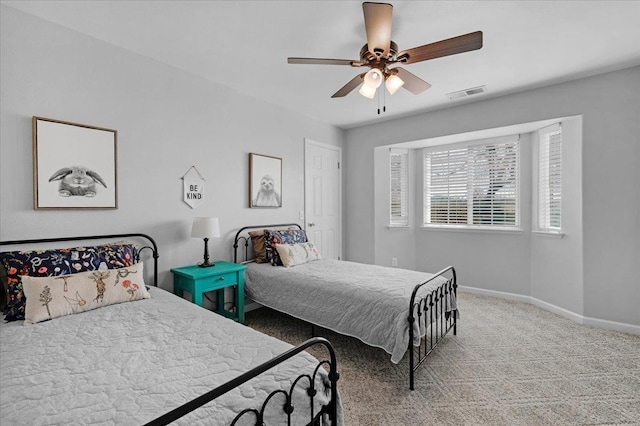 carpeted bedroom featuring visible vents, baseboards, and a ceiling fan