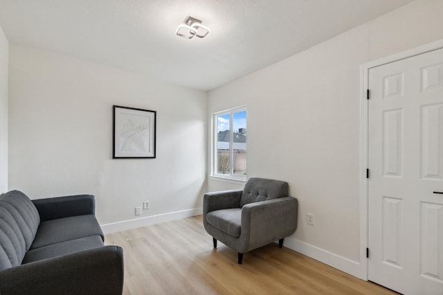 sitting room featuring baseboards and light wood-style floors