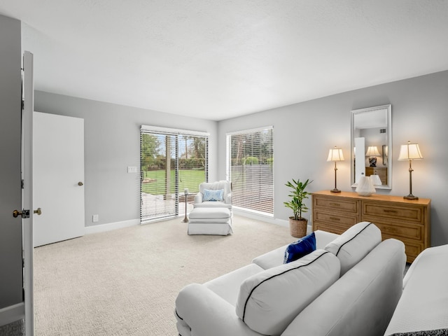 carpeted living area with baseboards