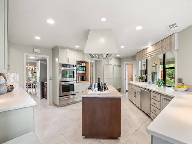 kitchen with light countertops, a warming drawer, recessed lighting, and stainless steel appliances