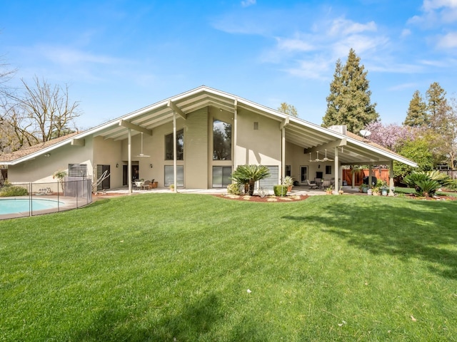 back of property featuring a patio area, stucco siding, a yard, and fence