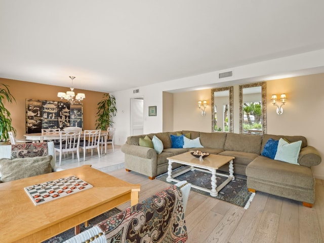 living area with a notable chandelier, visible vents, and wood-type flooring