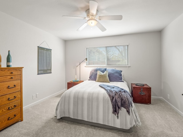 bedroom with light carpet, a ceiling fan, and baseboards