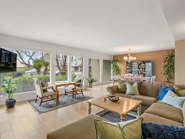 living area featuring light wood-type flooring and a chandelier