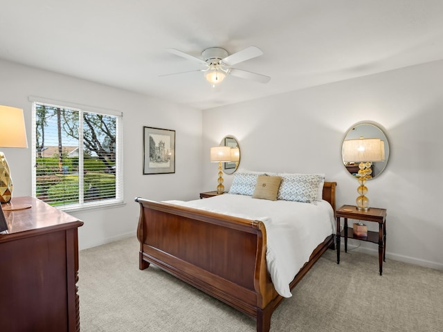 bedroom featuring baseboards, light colored carpet, and ceiling fan