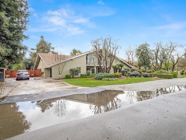 exterior space with stucco siding, a lawn, and concrete driveway