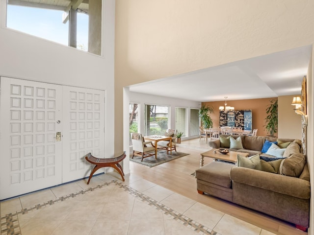 foyer entrance featuring a high ceiling, a notable chandelier, and light tile patterned floors