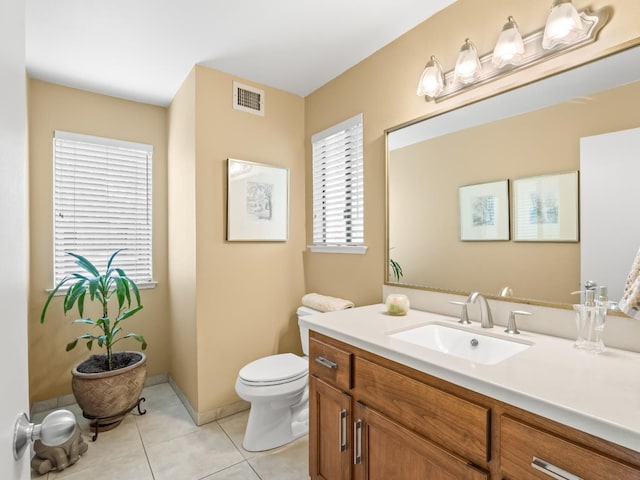 bathroom with vanity, baseboards, visible vents, tile patterned floors, and toilet