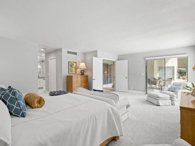 carpeted bedroom featuring access to exterior, visible vents, ensuite bathroom, and baseboards