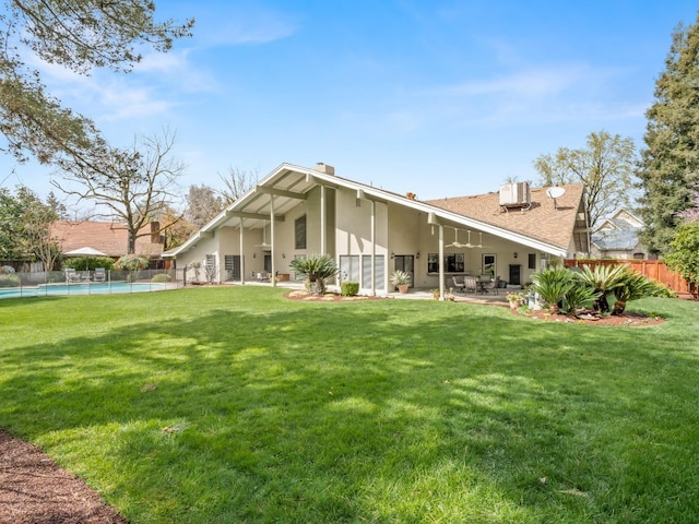 back of house with a fenced in pool, a lawn, a patio, and fence