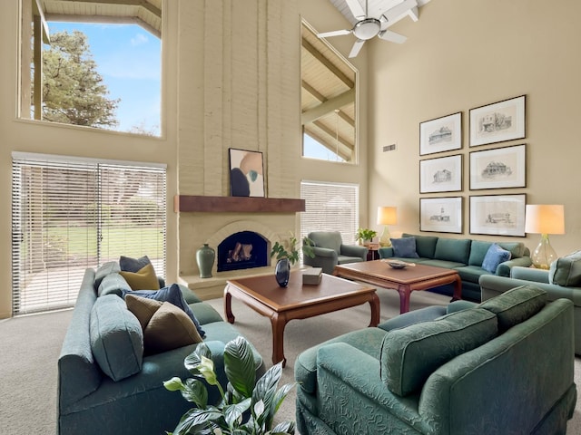 living area with visible vents, carpet floors, high vaulted ceiling, a fireplace, and ceiling fan