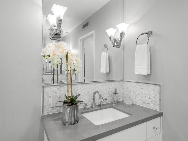 bathroom with vanity, visible vents, and backsplash