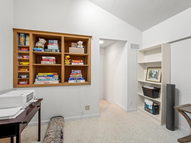 home office featuring visible vents, baseboards, lofted ceiling, carpet flooring, and a textured ceiling