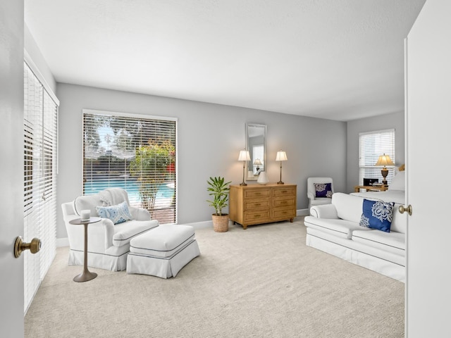 living area featuring carpet flooring and baseboards