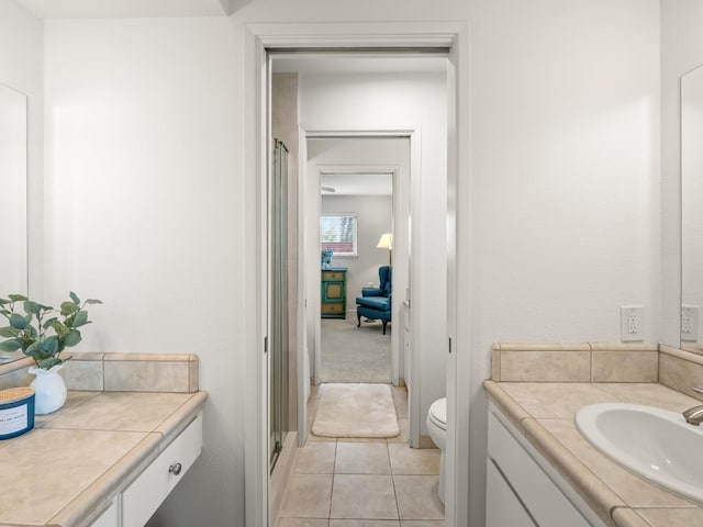 bathroom with tile patterned floors, toilet, a stall shower, and vanity