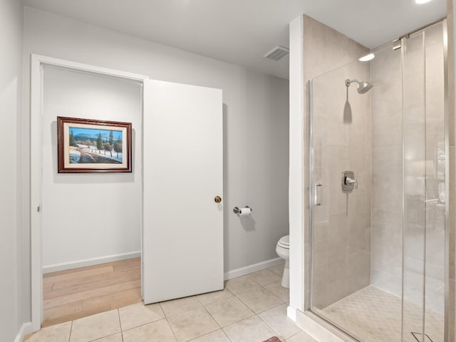 full bathroom featuring tile patterned floors, a shower stall, toilet, and baseboards