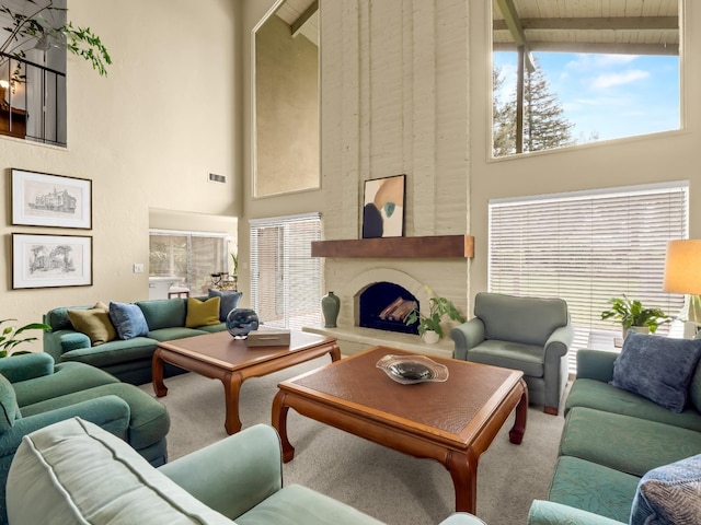 living area with a wealth of natural light, beamed ceiling, a large fireplace, and carpet