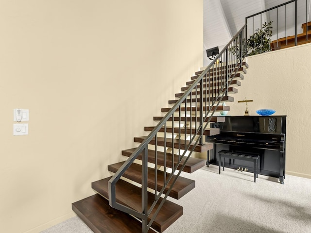 stairway featuring baseboards and carpet floors