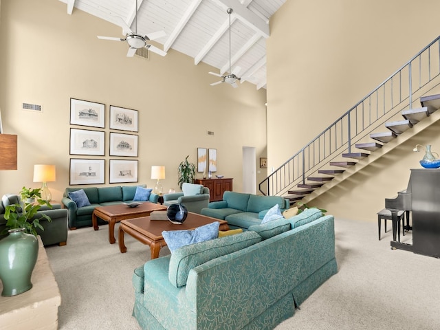 carpeted living room featuring stairway, visible vents, high vaulted ceiling, ceiling fan, and beamed ceiling