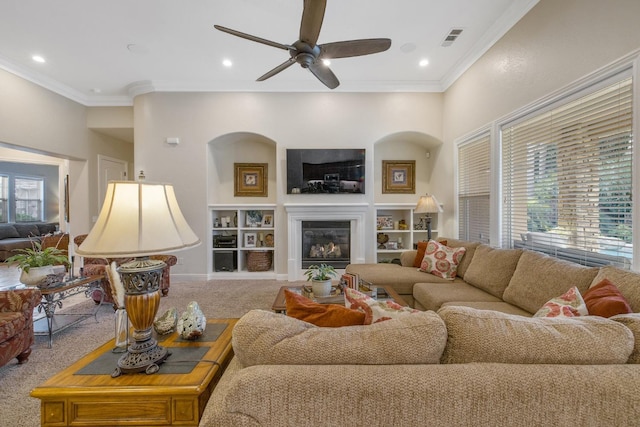 living area with visible vents, ceiling fan, carpet, and ornamental molding