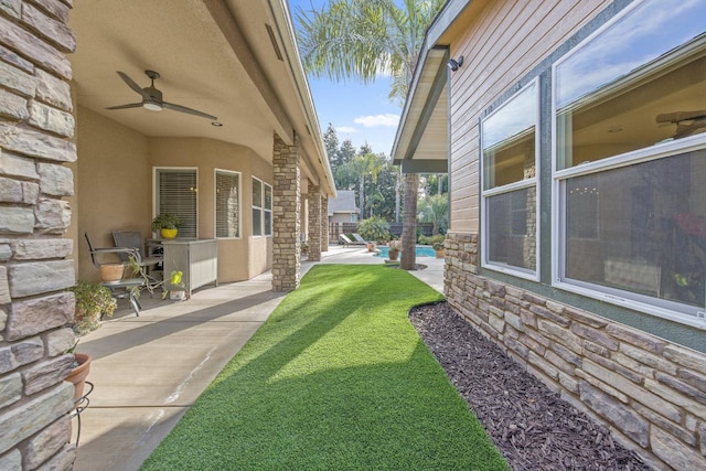 view of yard featuring a patio area, an outdoor pool, and a ceiling fan