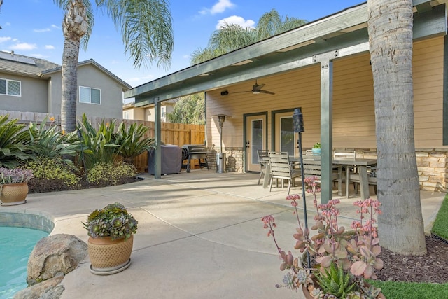 view of patio featuring outdoor dining space, fence, a fenced in pool, and ceiling fan