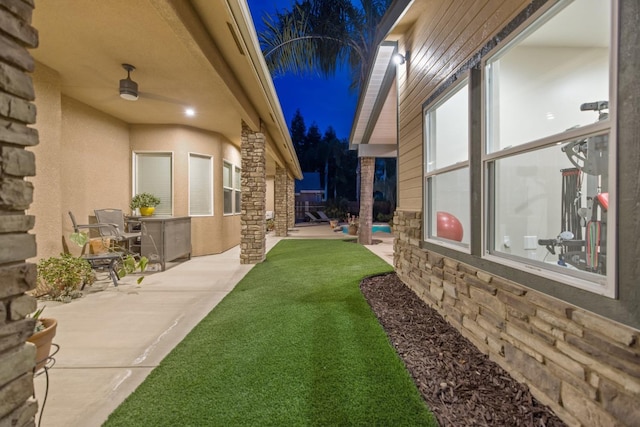 view of yard featuring a patio area and a ceiling fan