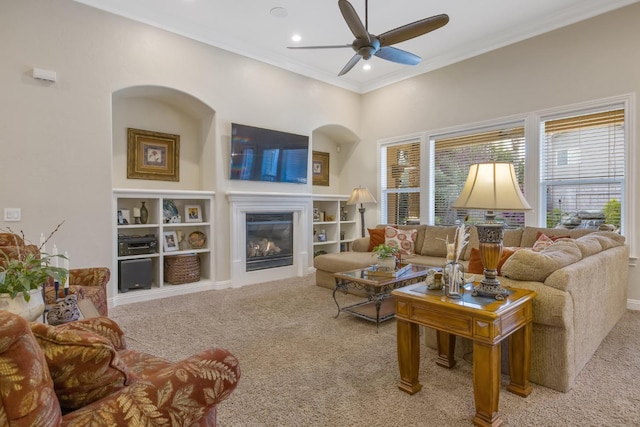 living area featuring crown molding, carpet flooring, recessed lighting, a glass covered fireplace, and a ceiling fan