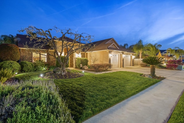 view of front facade with stucco siding, a front lawn, fence, concrete driveway, and an attached garage