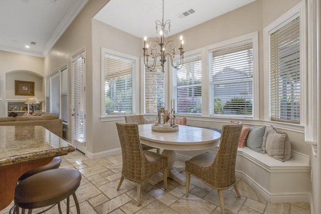 dining room featuring stone tile floors, a healthy amount of sunlight, baseboards, visible vents, and a chandelier